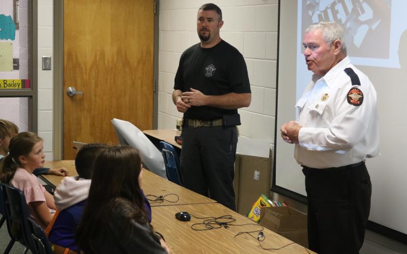 Sunshot by Grayson Williams - CHAMPS deputy Chris Carroll, left, and Hart County Sheriff Mike Cleveland speak to an elementary school class at South Hart Elementary School in 2019.