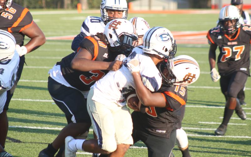 Pictured, several Bulldogs take down a Blue Devil ball carrier.