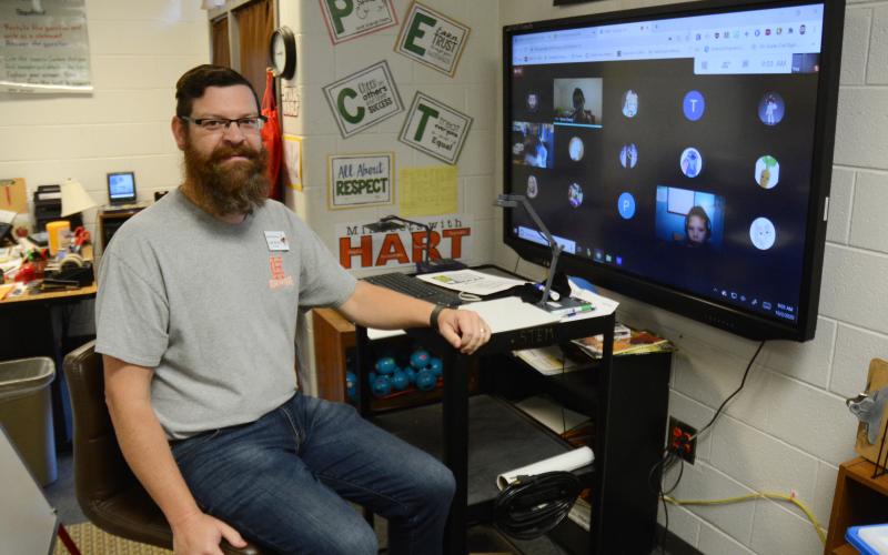 Sunshot by MIchael Hall - Josh McCurley poses for a photo at his virtual learning station where he is teaching third-grade virtual learners and will use a Bright Ideas Grant from Hart EMC to teach them circuitry.