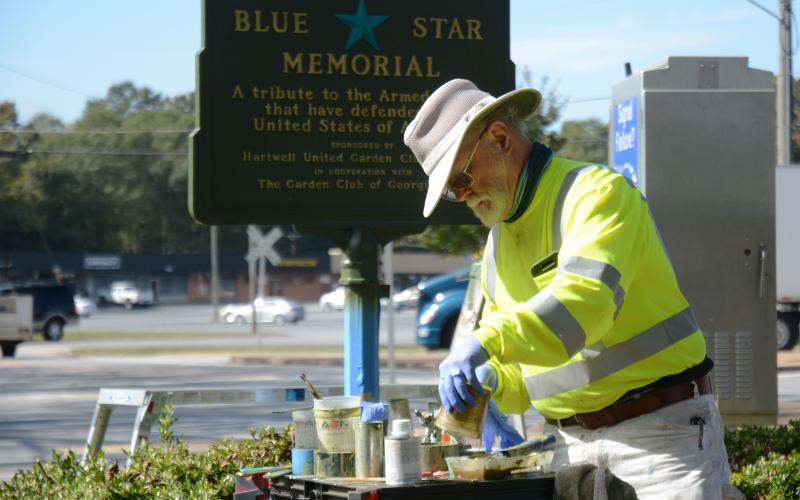 Tom Stelling mixes paint to use on restoration of the Blue Star Memorial on Oct. 25.