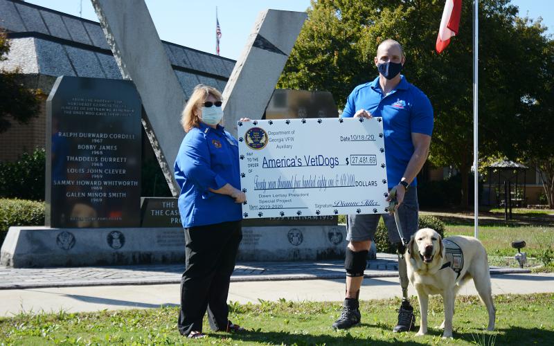Sunshot by Michael Hall - Dawn Lemay, a Hartwell resident and state president of the Veterans of Foreign Wars Auxiliary, presents a check for $27,481.69 to Joe Worley, of America’s VetDogs, and his service dog Galaxie recently at the veterans memorial on the square at the Hart County Courthouse.