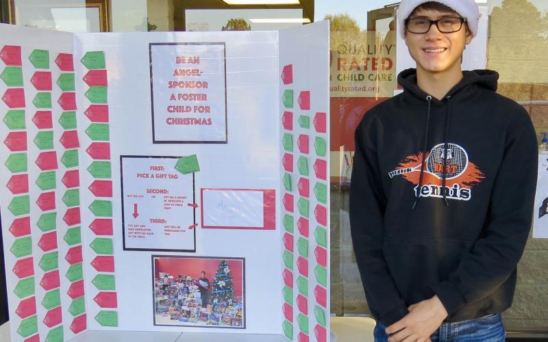 Photo submitted  - Ben Tellano poses for a photo with the Angel Tree display at the Bell Family YMCA recently.