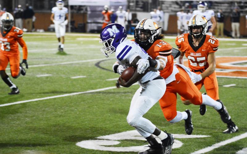 Ty Shiflet wraps up a Monroe Area ball carrier as Aiden Myers follows up to help