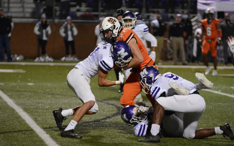 Cane Berrong battles for more yards against multiple defenders.