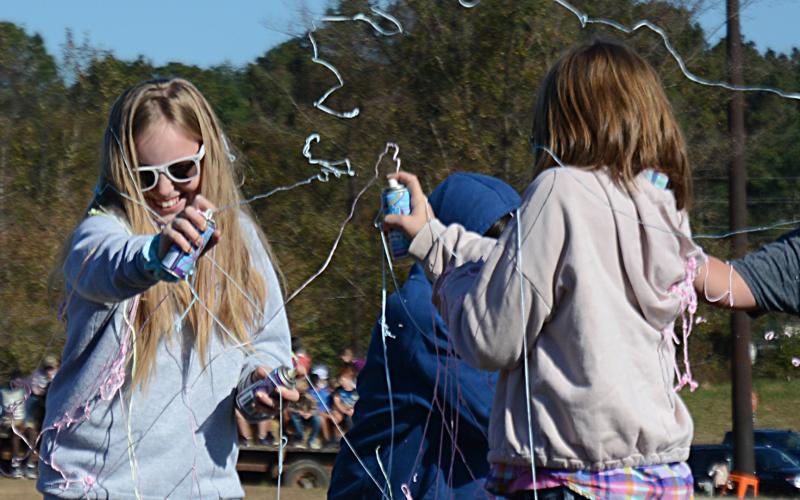 Brooklyn Vassar, left, and Mia Dancause, right, both fifth-graders, duel with cans of silly string during the Silly String Club Day activity.