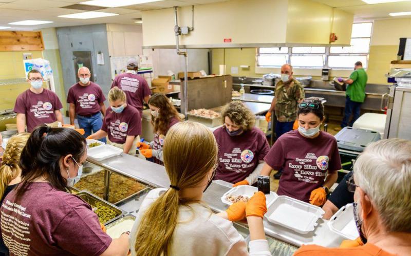 Volunteers put together Thanksgiving dinners during a recent event hosted by Love Him Love Them Ministries.