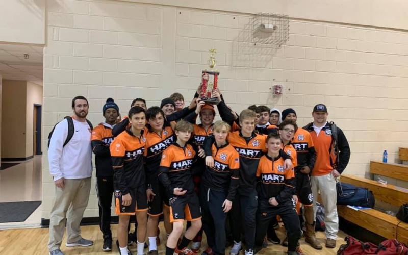 Photo submitted - The Hart County wrestling team holds up its first-place trophy after winning the “King of the Mountain” tournament on Dec. 5 in Towns County.
