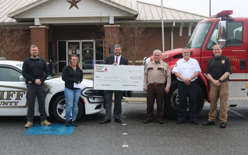 Sunshot by Grayson Williams Pictured from left to right during an arson reward ceremony are Hart County Inv. Chris Carroll, reward recipient Samantha Lack, Georgia Arson Control representative Kenneth Lecroy, Hart County Sheriff Mike Cleveland, Hart County Fire Chief Jerry Byrum and Georgia State Fire Marshal’s Office representative Brian Smith.