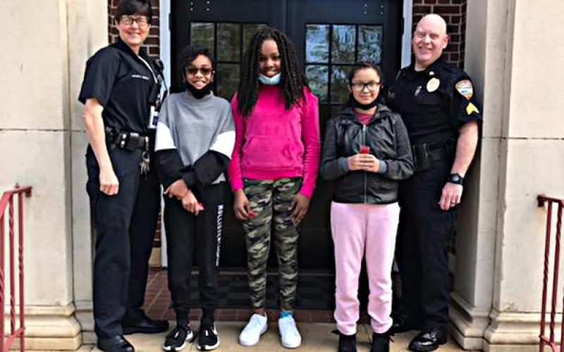 Pictured are officers Kay Ankerich, left, and Paul Agnew, right, with essay winners Chyna Orsley, from left to right in the middle, Audrey Harper and Sariyah Heard.