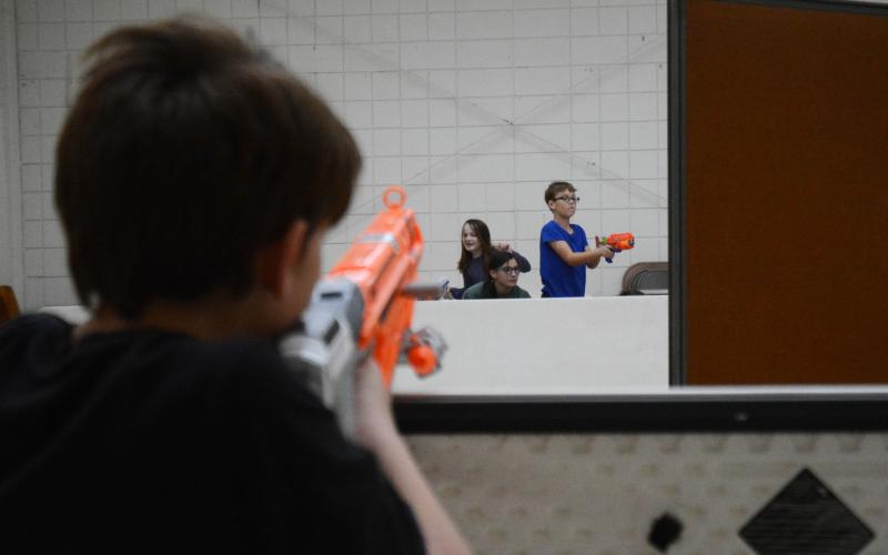 Sunshots by Michael Hall - Xavier Johnson, left, takes aim at Emilee Shaw, second from left, Lilly Palmer, second from right, and Blake Allgood, right, during a Nerf gun battle on Tuesday, Feb. 16, at HYDRA during the program’s winter break camp.
