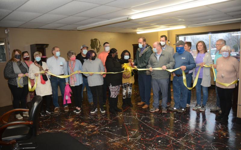 Owner Natasha Fields, pictured in the center with the scissors, is joined by her daughter Taryn Fields, to her left, fiance Daryl Denney, behind her, and her mother, Thelma Bowens, as well as members of the Hart County Chamber of Commerce board of directors, Mayor Brandon Johnson, councilman Tray Hicks, and members of Hartwell Main Street and the Downtown Development Authority.