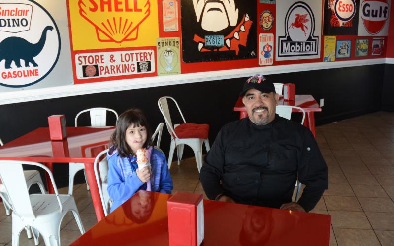 Omar Vega, right, and his daughter, Anna Blazek, left, sit in the newly remodeled Scoops by Rolling Chefs.