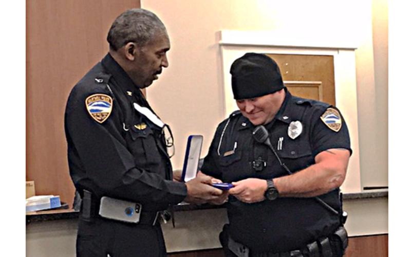 Hart County police chief Anthony Davis, left, presents officer Matthew Dutton with the department's Medal of Valor recently.