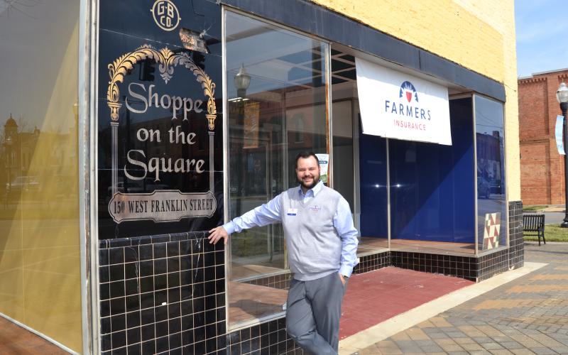 Sunshot by Drew Dotson - Major Harris poses outside the old Shoppe on the Square building in downtown Hartwell that now houses his Farmers Insurance agency.
