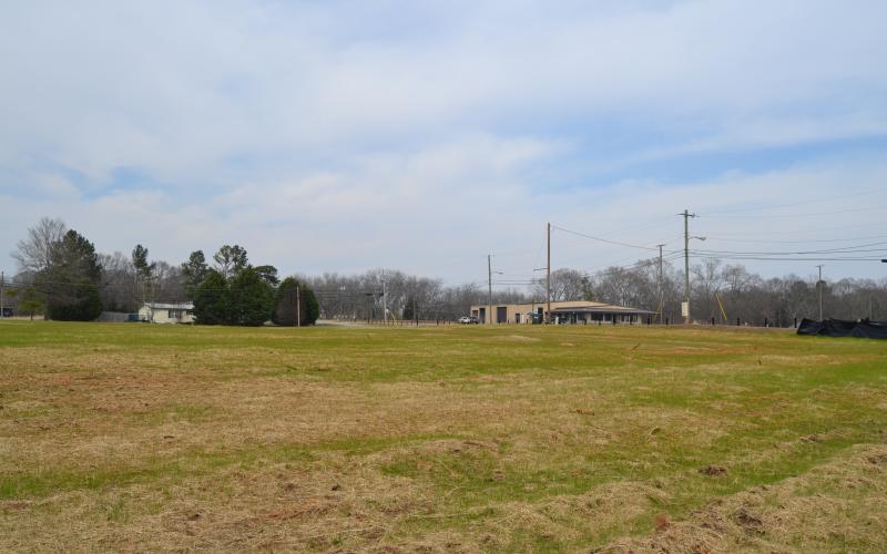 Sunshot by Drew Dotson - The now empty lot at 55 Ridge Road is shown where a house once sat with the old Ed Murdock dealership in the background across the street.