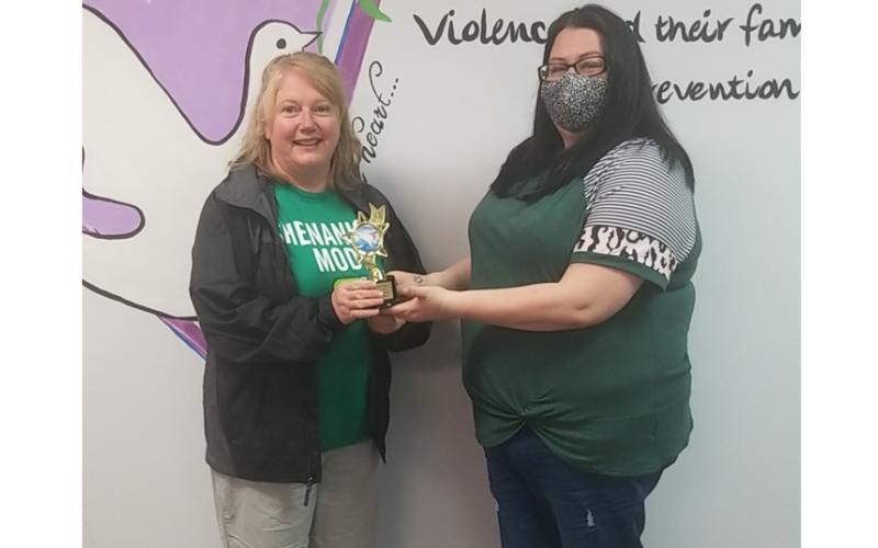 Photo submitted Sharon Swint, left, accepts a trophy recently from the Northeast Georgia Council on Domestic Violence representative Kayla Wilson for taking the Polar Bear Plunge for 25-straight years.