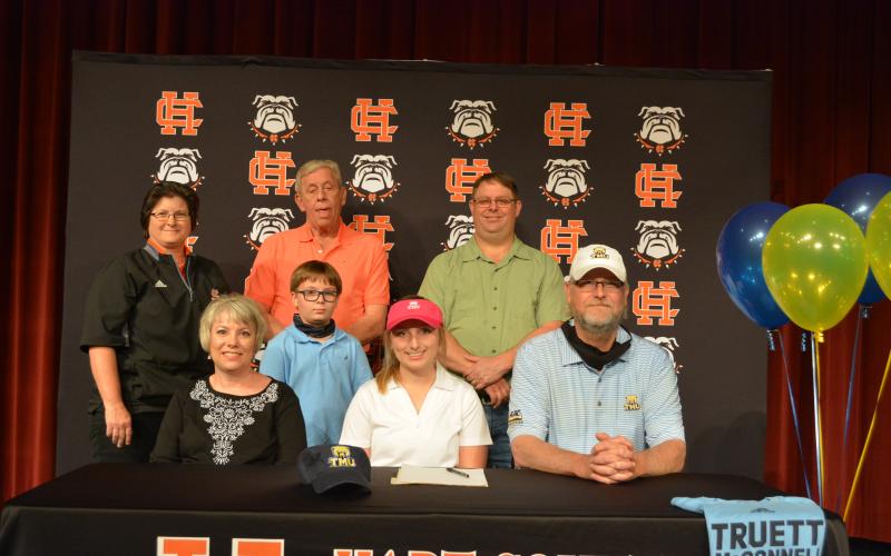 Sunshot by Drew Dotson Lauren Weaver is pictured with her parents Joe and Gina Weaver, Hart County head coach Wende Peloquin, Truett McConnell head golf coach Steve Patton, her grandfather Danny Weaver and her brother Boone Weaver.