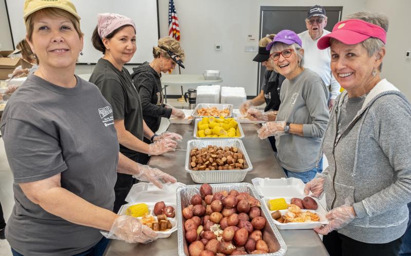 Pictured are volunteers at the May 7 Lowcountry boil. Starting on the left row from the left is Debbie Wray, Angela Short, Marilyn Bowen. On the right row starting from the left is Anne Hinson, Kate Kirby, Brigid Richardson. Paul Abernathy looks on from the back right.