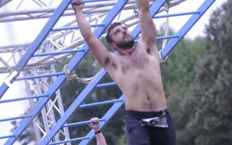 Buchanan traverses the monkey bars on an obstacle course.