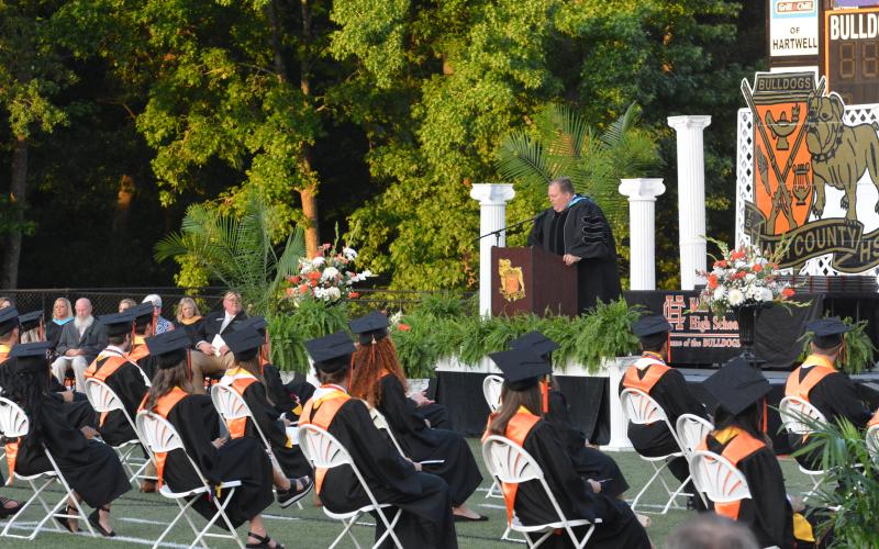 Drew Dotson/The Hartwell Sun - HCHS Principal Kevin Gaines addresses the crowd with the teachers and honor graduates listening.