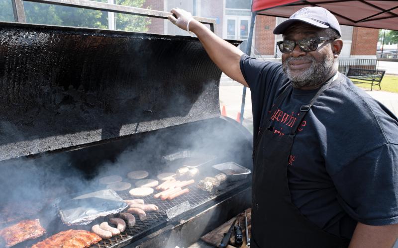Willie Applewhite proudly displays his collection of meats on the grill in Hartwell on Saturday.