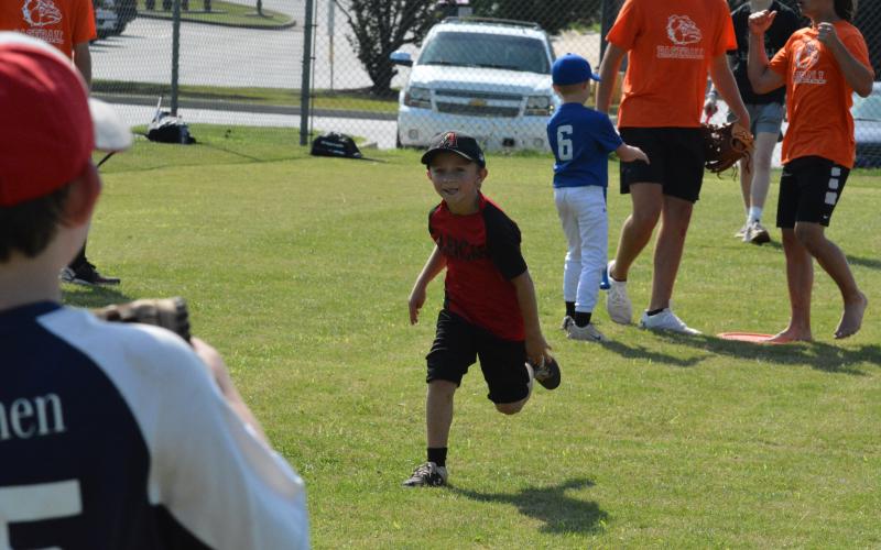 Rhett McGowen runs to first after getting a hit at baseball camp.