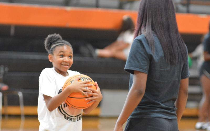 Dakota Wiley receives instruction from rising senior basketball player Kiyasia Montgomery.