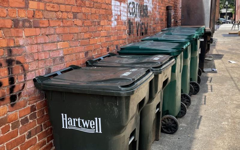 Drew Dotson/The Hartwell Sun - Trash cans line the walls of the alley shared by downtown businesses.