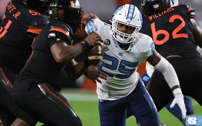 Photo from GoHeels.com - Hart County graduate Kaimon Rucker keeps his eyes on the football as he battles through Miami blockers trying to get to quarterback D’eriq King in Miami on Dec. 12.