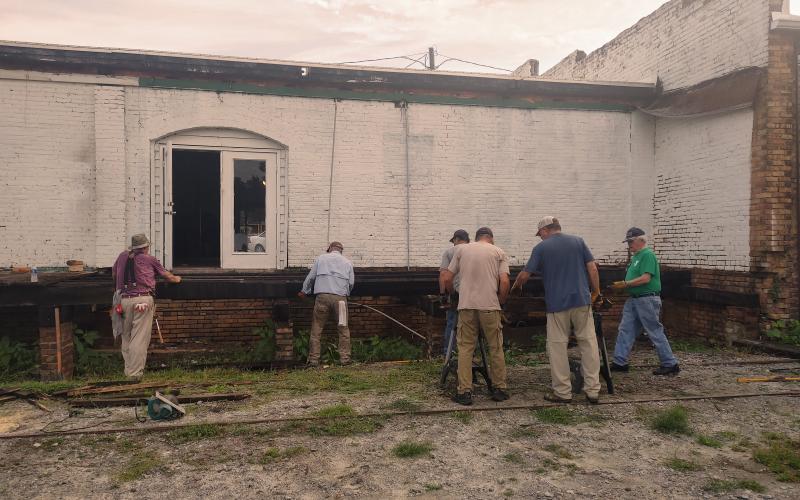 Dan Hunt/The Hartwell Sun - Kiwanis Club members clear out the old Railroad Street-side back deck at 41 Depot Street and prepare to build a replacement that will compliment a breezeway between Depot and Railroad Streets,