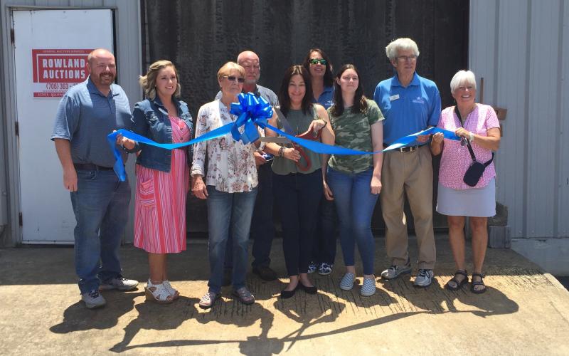 Josh Brannen/The Hartwell Sun - Hartwell Main Street and Hart County Chamber of Commerce members join Angie Rowland (scissors) for Rowland Auctions’ ribbon cutting.