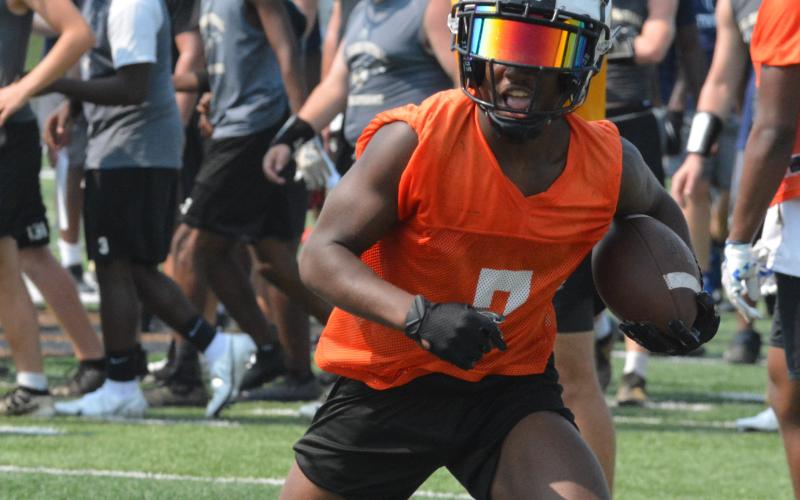 Running back Nori Moore jukes a defender from a South Carolina school.