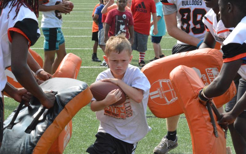 A camper runs the gauntlet before diving into the padded endzone.