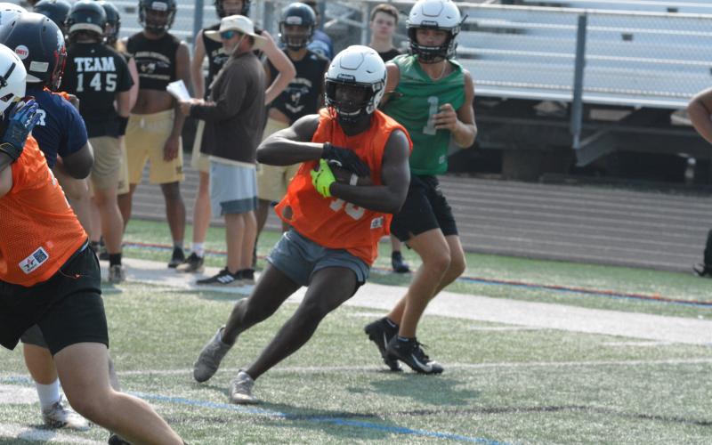 JL Lackey takes a handoff from quarterback Austen Whitworth at a camp over the summer in South Carolina.
