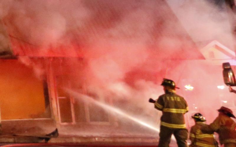 Firefighters work to extinguish a fire Tuesday in the former Royce Theatre building in downtown Royston. The building was being used for storage at the time of the fire, which was contained to just that building.