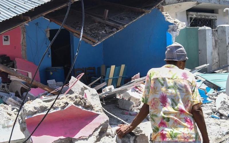 A Haitain woman surveys damage to her home after Saturday's earthquake.
