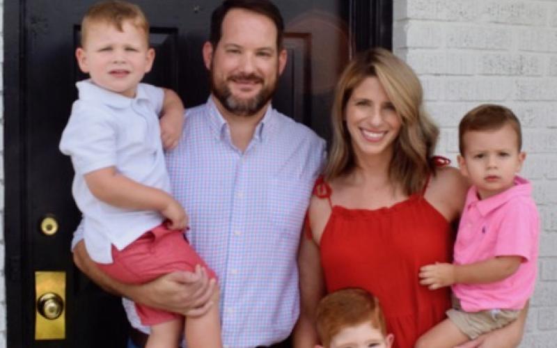 Dan Leard, wife Collen and their kids smile in front of their home.