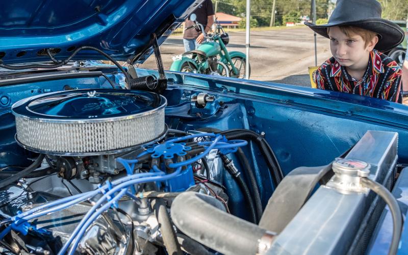Wyatt Smith (8) admiring the engine of a 1969 Mach 1 Mustang.