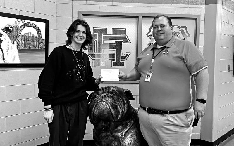Principal Kevin Gaines presents student Ethan McDowell with his commended student designation.