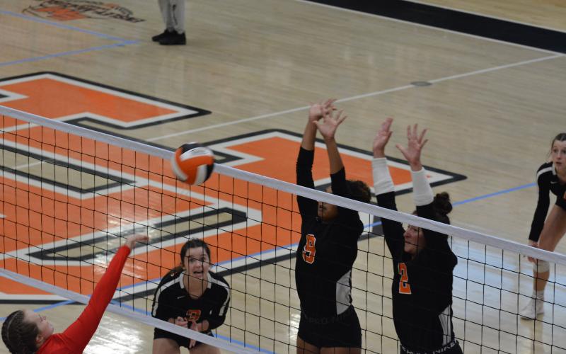 Alexis Walker (9) and Lille Kate Rogers (2) block the Madison attack as Aliza Hart (3) waits to make a play.