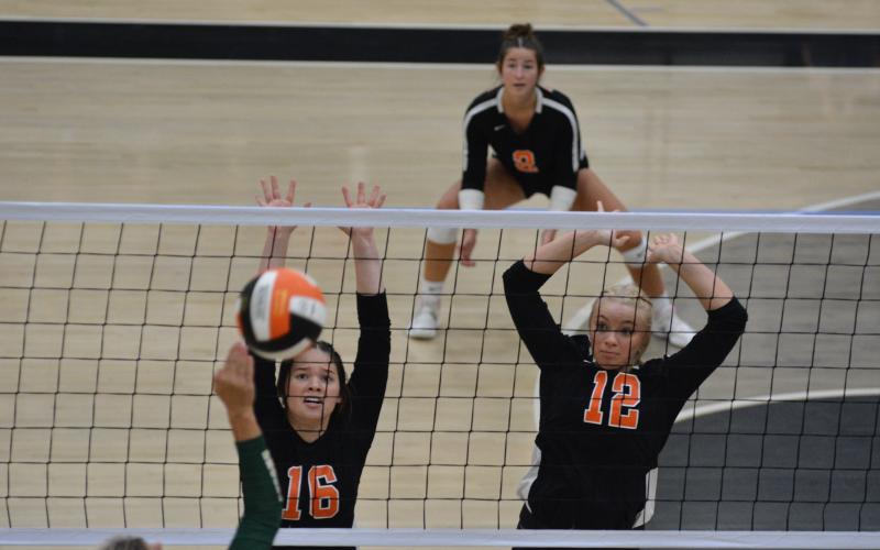 Caitlyn Key (16) and Cali Beebe (12) go up to block the attack.