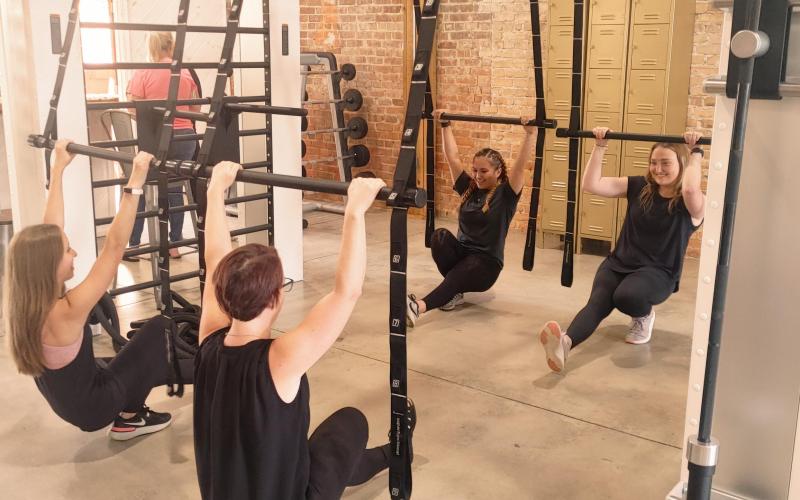 Physique Boutique employee (L-R) MattiGrace, Ashley Barry, Miyana Vaca and Lauren Lee demonstrate techniques on the gym's suspension bars.