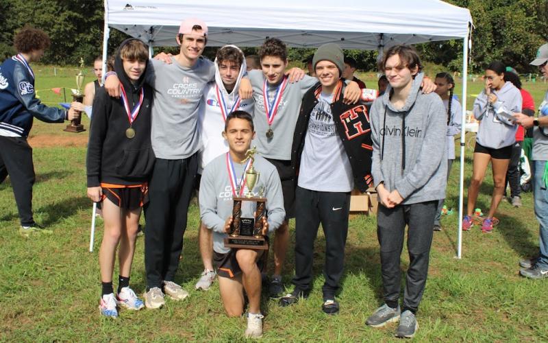 The boys country team pose with their second place trophy after the region meet on Oct. 27.