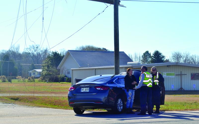 Officers talk to a driver after a wreck that took down a power line along Royston Highway,
