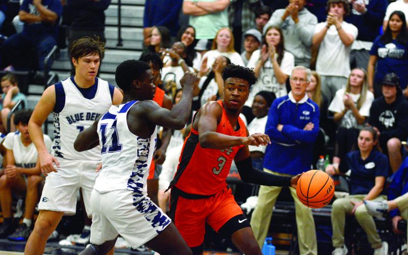 Tahj Johnson fights off Elbert defenders in the last home basketball game on Dec. 3.