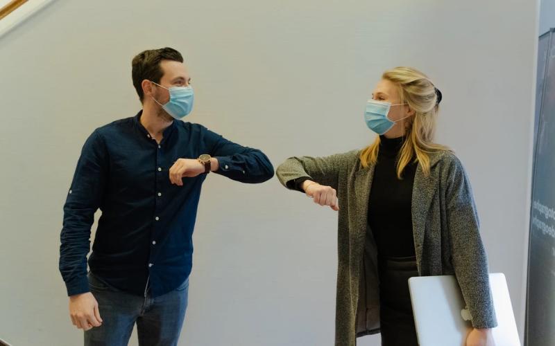 Man and woman practice COVID protocols. Photo credit: Maxime