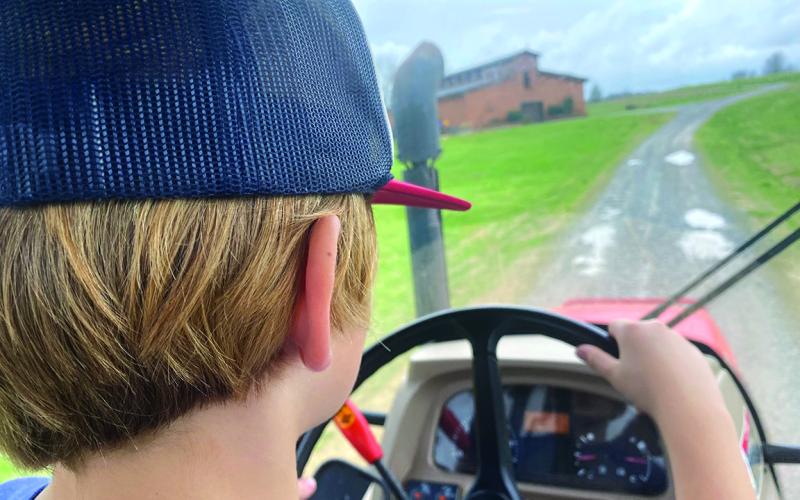 Nine-year-old Bayard, son of Eric and Connell NeSmith, takes us on a ride around the farm in our diesel tractor with an enclosed cab.