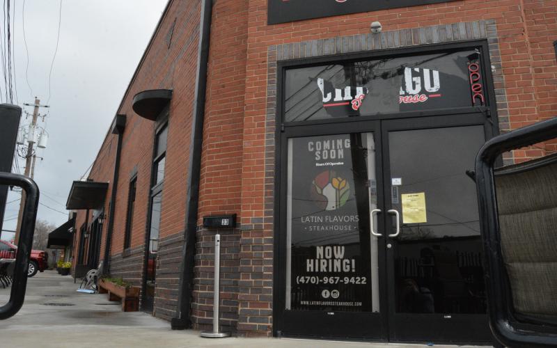 A sign indicating that Latin Flavors will be “coming soon” currently on the door at  33 Carolina Street.