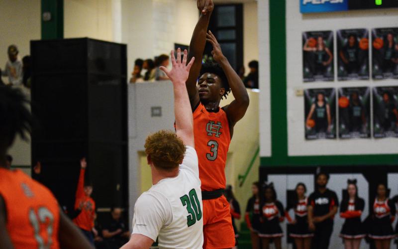 Tahj Johnson shoots over the tall Lions center.
