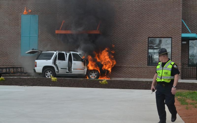 A car at the drive-thru window of Popeyes Chicken in Hartwell engulfed in flames Tuesday. The car, occupied by a family of five was picking up food when their vehicle caught fire. No one was harmed and the cause of the fire is unknown.